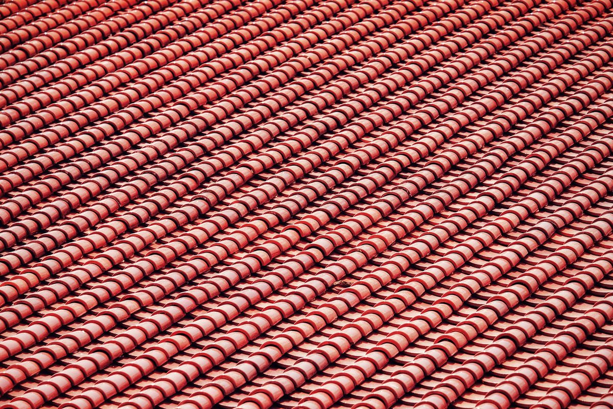 Überlappende Reihen roter Dachziegel, schräg von oben fotografiert