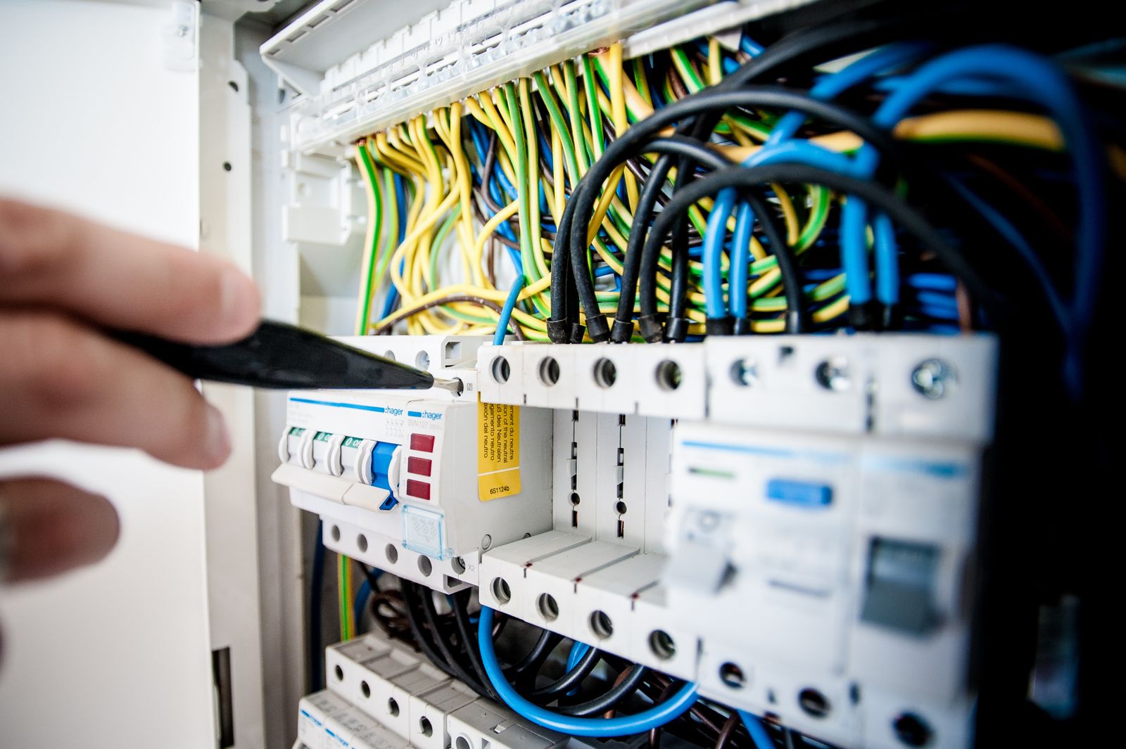 Elektriker bei der Arbeit an einem geöffneten Schaltschrank
